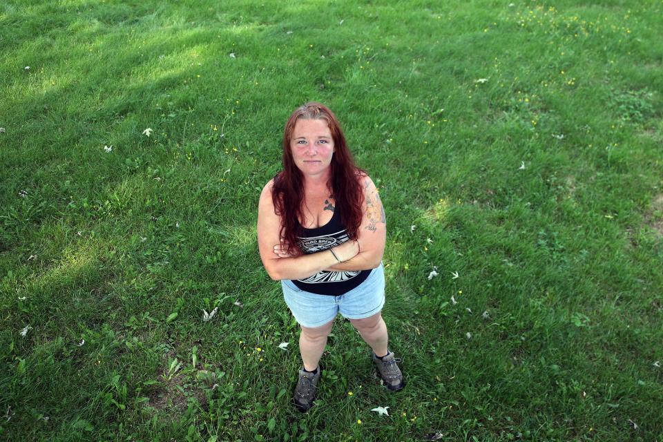 Jacqui Pierce of Somersworth, seen in her yard Wednesday, Sept. 6, 2023, refuses to cut grass until the yellow flowers die because bees have been swarming within them.