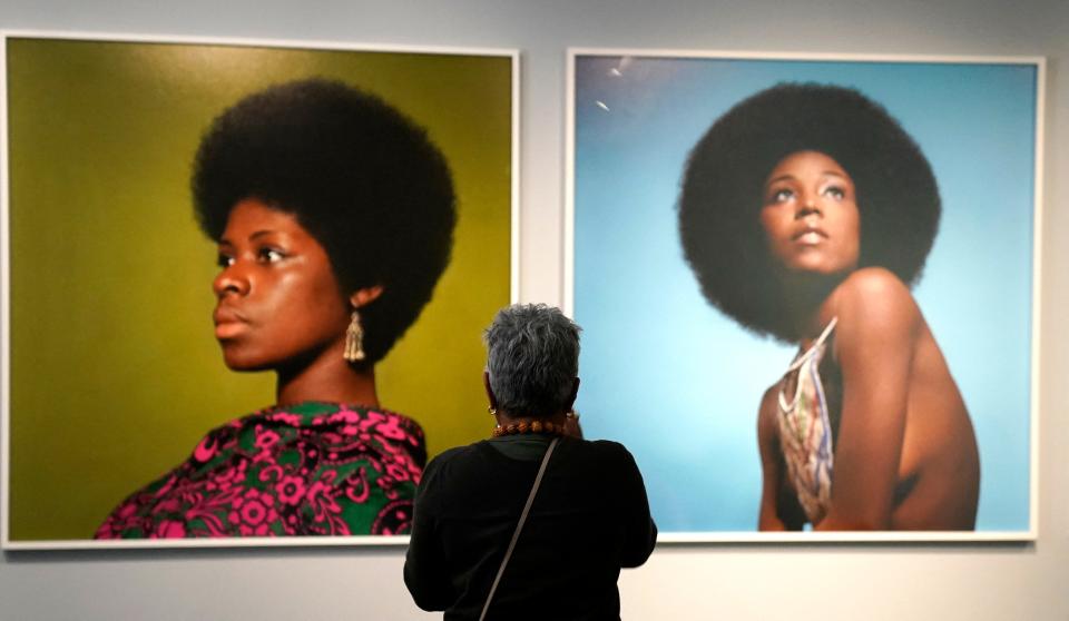 A person walks past the photos of Kwame Brathwaite (Brooklyn, New York, 19382023) during a press preview of the exhibition Giants Art from the Dean Collection of Swizz Beatz and Alicia Keys at the Brooklyn Museum in New York on February 6, 2024.