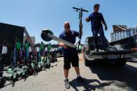 John Heinkel and Dan Borelli unload a truckload of impounded scooters at their Scoot Scoop facility in San Diego, California