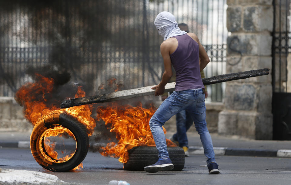 <p>Palestinians burn tires during clashes with Israeli troopsin the West Bank city of Bethlehem during a protest against the U.S. decision to relocate its Israeli embassy to Jerusalem, May 14, 2018. (Photo: Majdi Mohammed/AP) </p>