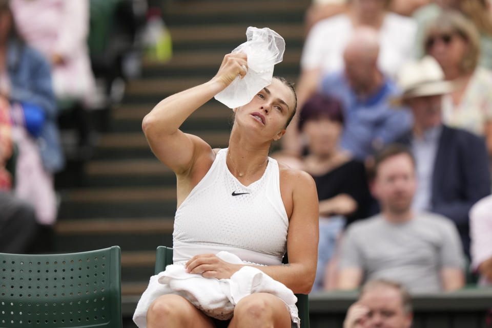 Aryna Sabalenka of Belarus sits in her chair and tries to cool down with an ice pack during a change of ends break against Tunisia's Ons Jabeur in a women's singles semifinal match on day eleven of the Wimbledon tennis championships in London, Thursday, July 13, 2023. (AP Photo/Alberto Pezzali)