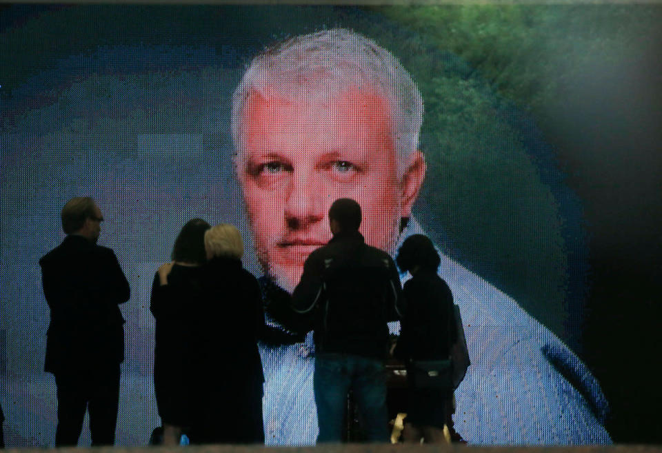 <p>A portrait is displayed as colleagues and people gather at the coffin of Pavel Sheremet to pay their respects at his memorial ceremony in Kiev, Ukraine, Friday, July 22, 2016. Hundreds of local residents and journalists have come to pay their respects to a prominent journalist who died in a car bombing in the Ukrainian capital of Kiev earlier this week. (AP Photo/Efrem Lukatsky)</p>