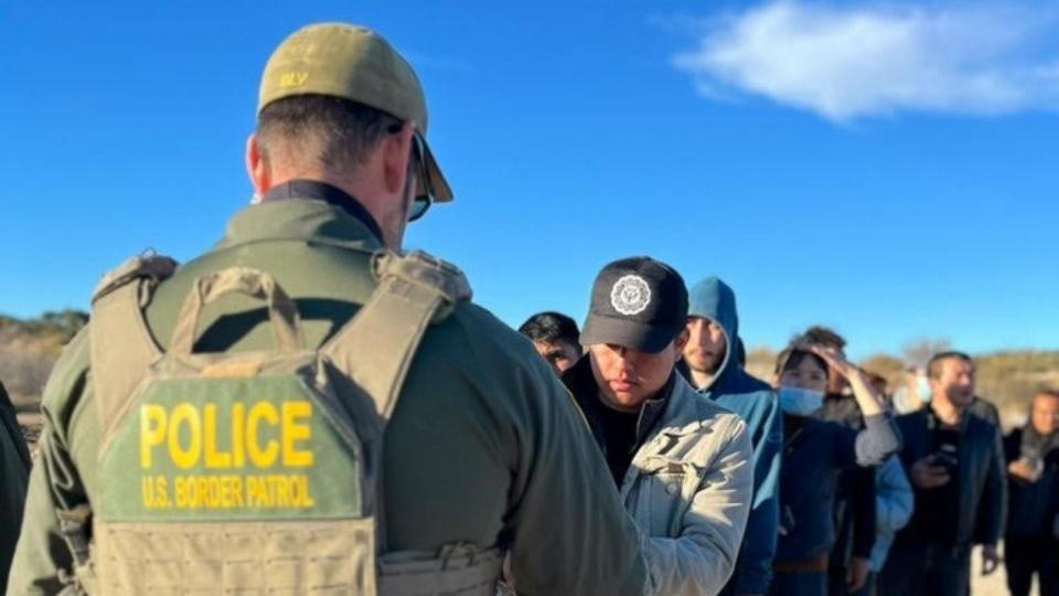 PHOTO: A Border Patrol agent is shown giving migrants bracelets (Mireya Villarreal/ABC News)