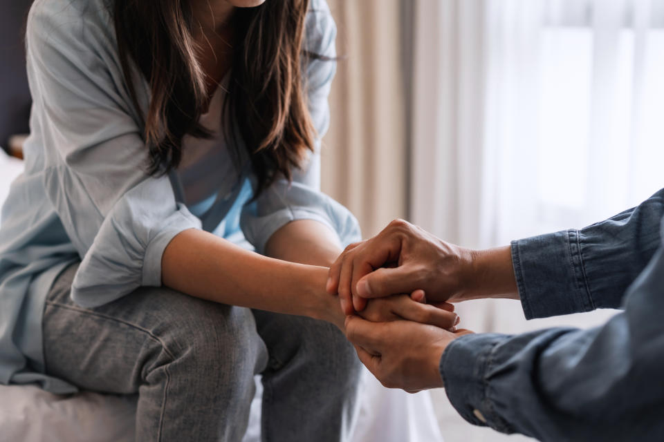 two friends holding hands talking