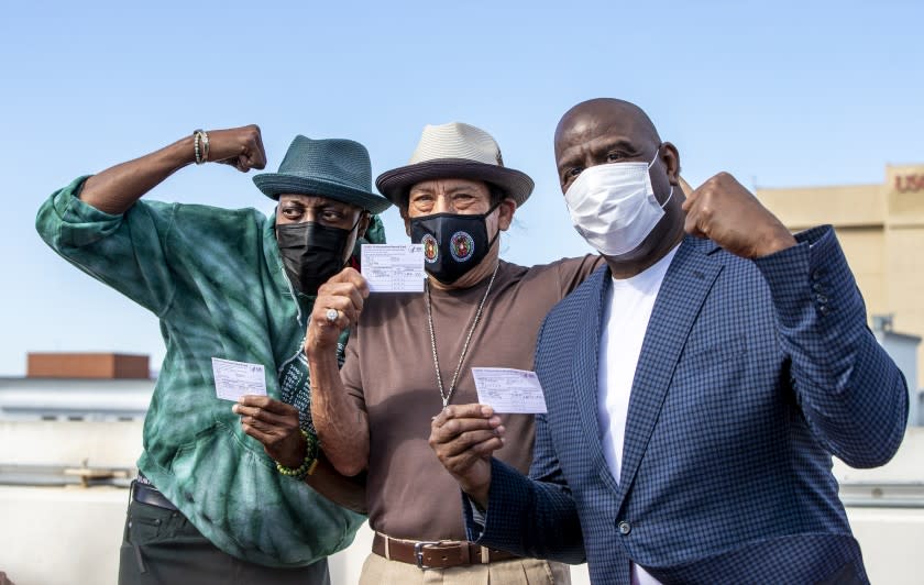 LOS ANGELES, CA - MARCH 24, 2021: Arsenio Hall, left, Danny Trejo and Magic Johnson pose for a photo after they all got vaccine shots on the rooftop of parking structure at USC as a part of a vaccination awareness event at USC on March 24, 2021 in Los Angeles, California. (Gina Ferazzi / Los Angeles Times)