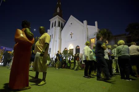 People stand outside during a vigil outside Emanuel African Methodist Episcopal Church in Charleston, June 20, 2015. REUTERS/Carlo Allegri