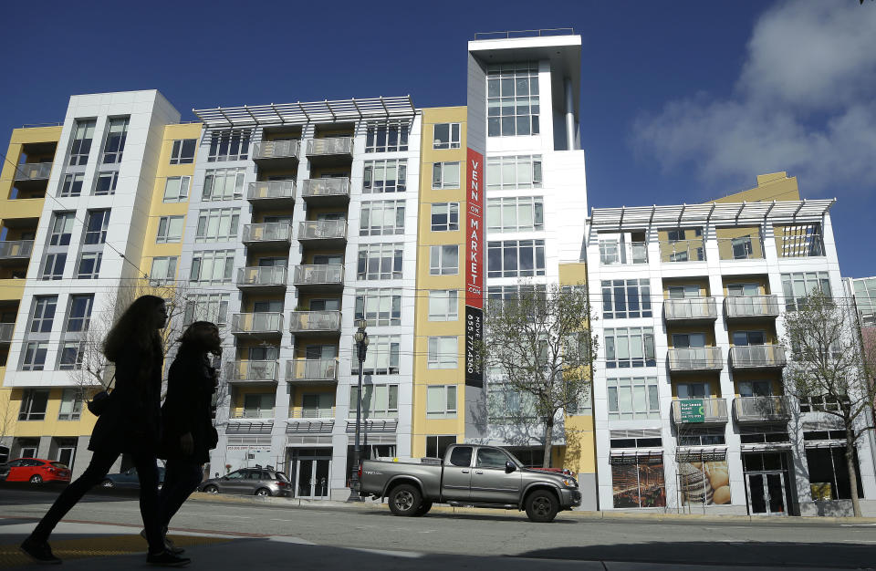 Two women walk across the street from the Venn on Market apartment and condominium building in San Francisco, Monday, March 17, 2014. San Francisco will now lend as much as $200,000 to some homebuyers toward a down payment on their first house or condominium. Mayor Ed Lee's decision to double the previous limit of $100,000 was intended to help middle-class residents who have been hit hard by the housing crunch. (AP Photo/Jeff Chiu)