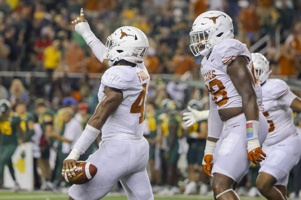 Texas linebacker Jaylan Ford (41) celebrates his interception of a Baylor pass with defensive end Barryn Sorrell (88) during the second half of an NCAA college football Saturday, Sept. 23, 2023, in Waco, Texas. (AP Photo/Gareth Patterson)