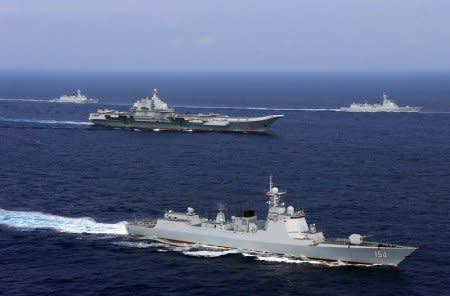 FILE PHOTO - China's aircraft carrier Liaoning (C) takes part in a military drill of Chinese People's Liberation Army (PLA) Navy in the western Pacific Ocean, April 18, 2018. Picture taken April 18, 2018. REUTERS/Stringer