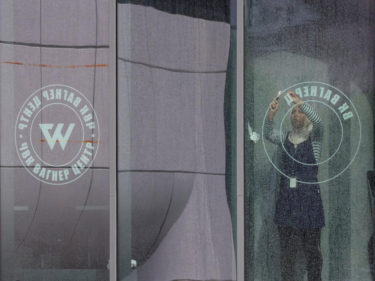 A staff removes logo on a window of the ‘PMC Wagner Centre' (REUTERS)