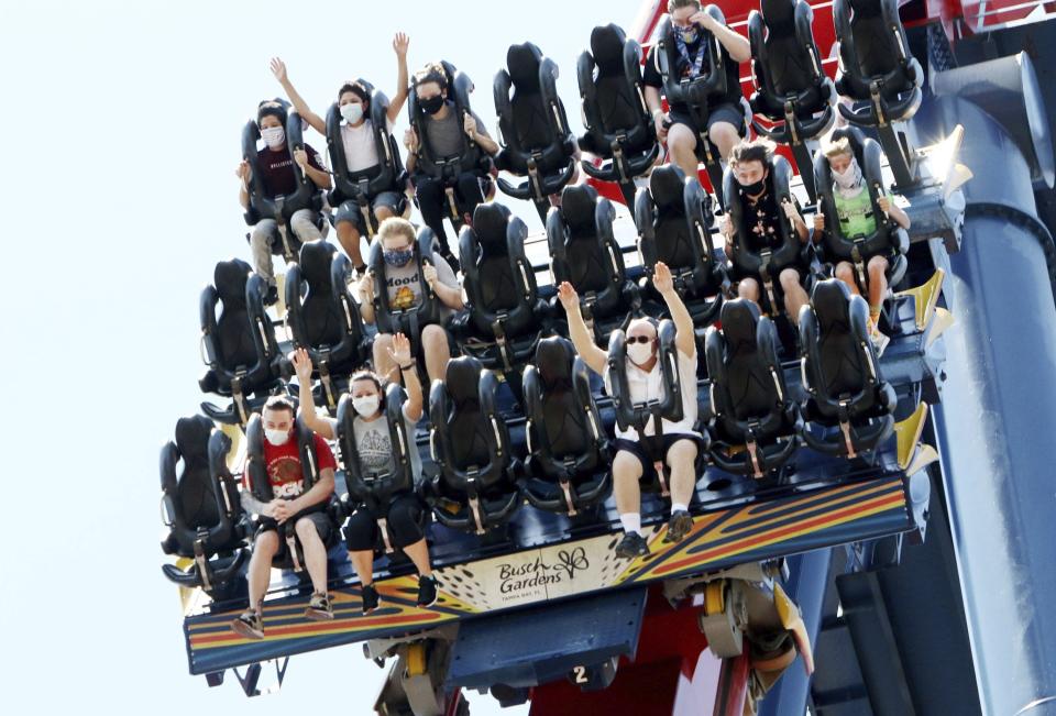 Patrons of Busch Gardens Tampa Bay enjoy the 200-foot dive on the SheiKra roller coaster, Thursday, June 11, 2020, in Tampa. The park, owned and operated by SeaWorld Entertainment, has reopened to the public for the first time in almost 3 months after closing on March 16 because of the coronavirus pandemic. (Douglas R. Clifford/Tampa Bay Times via AP)