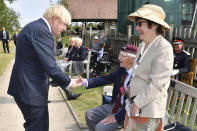 Britain's Prime Minister Boris Johnson shakes hands with veteran Arnold Hutchinson from the Parachute Regiment following the national service of remembrance marking the 75th anniversary of V-J Day at the National Memorial Arboretum in Alrewas, England, Saturday Aug. 15, 2020. Following the surrender of the Nazis on May 8, 1945, V-E Day, Allied troops carried on fighting the Japanese until an armistice was declared on Aug. 15, 1945. (Anthony Devlin/PA via AP)