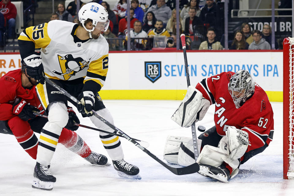 Carolina Hurricanes goaltender Pyotr Kochetkov (52) blocks a shot by Pittsburgh Penguins' Ryan Poehling (25) during the first period of an NHL hockey game in Raleigh, N.C., Sunday, Dec. 18, 2022. (AP Photo/Karl B DeBlaker)