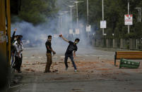 <p>Kashmiri students throw stones on Indian policemen as they clash in Srinagar, Indian controlled Kashmir, May 9, 2017. The students have been protesting since last month against a police raid in a college in southern Pulwama town in which at least 50 students were injured. (Photo: Mukhtar Khan/AP) </p>