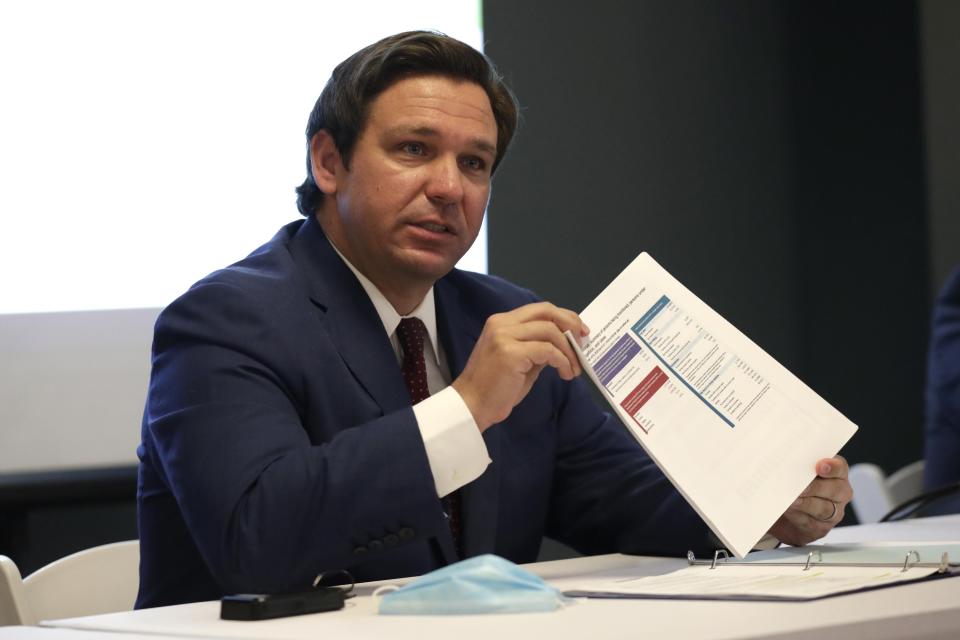 Florida Gov. Ron DeSantis holds up a document while discussing the coronavirus pandemic during a July 2020 news conference held at the Pan American Hospital in Miami.