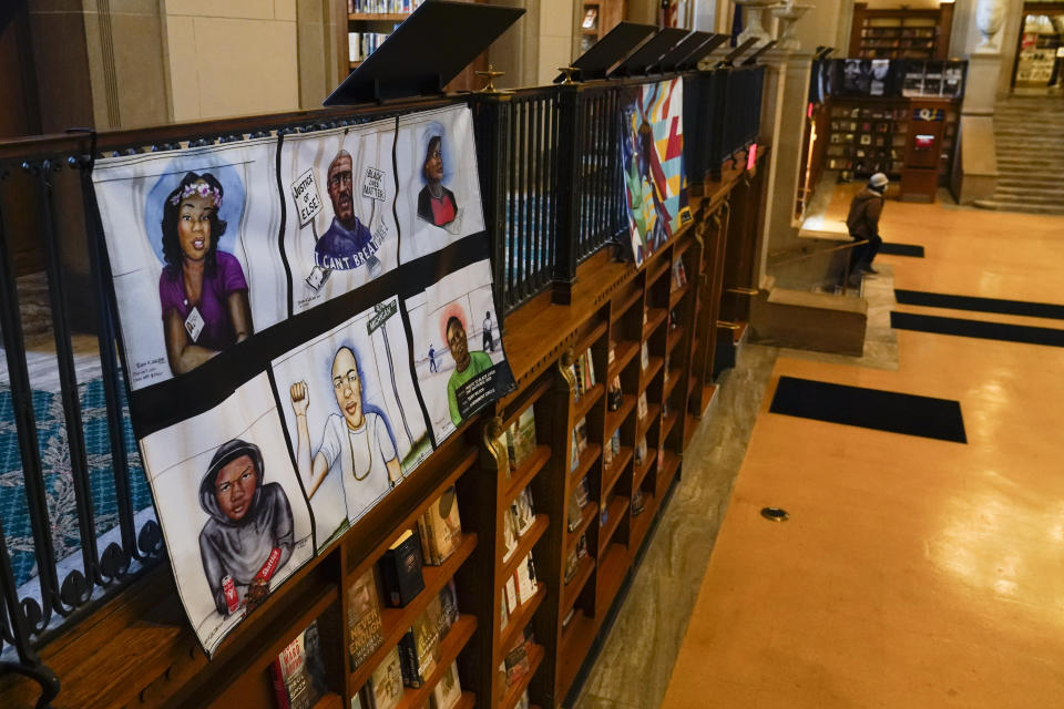 Vinyl banners representing the 24 murals that were painted in the downtown area of Indianapolis are displayed at the Central Library, Thursday, Dec. 10, 2020. During protests after George Floyd’s death, the streets of countless major cities became temporary galleries of artwork conveying collective pain and anger. But as these ephemeral artworks began to come down or be wiped from walls, patchworks of artists and activists rushed to preserve them. (AP Photo/Darron Cummings)