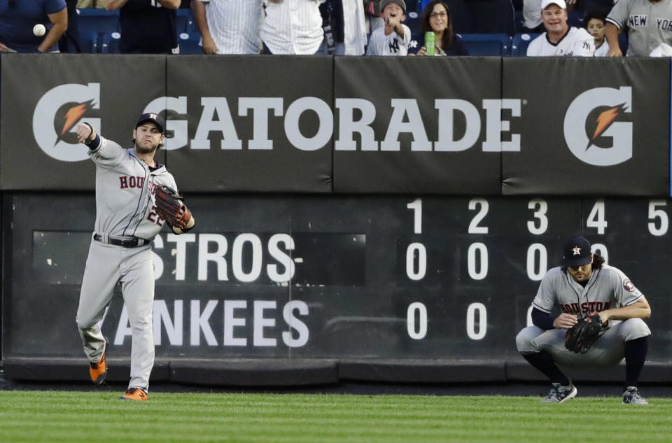 Houston Astros right fielder Josh Reddick, left, throws the ball to the infield as center fielder Jake Marisnick reacts after New York Yankees' Luke Voit reached on a fielding error by Marisnick during the fourth inning of a baseball game Saturday, June 22, 2019, in New York. (AP Photo/Frank Franklin II)
