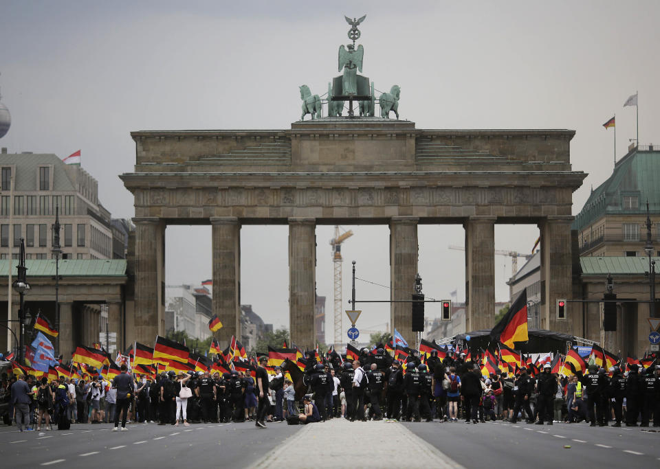 FILE - In this Sunday, May 27, 2018 file photo, AfD supporters wave flags in front of the Brandenburg Gate in Berlin, Germany. Migration is a side issue in this year's German election campaign for the national elections on Sept. 26, but that hasn't stopped the country's biggest far-right party from trying to play it up. (AP Photo/Markus Schreiber, File)