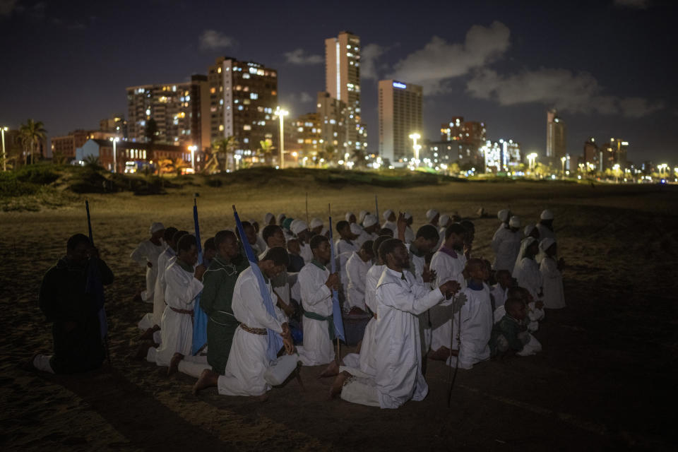 Worshippers of Intokozo Yamakrestu Church in Christ pray as they prepare for baptism on a Durban beach, South Africa, Monday, May 27, 2024. (AP Photo/Emilio Morenatti)