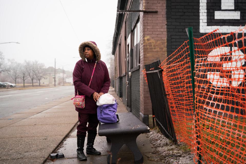 Tonya Hogan, 50, waits at a bus stop after visiting a donation center and the public library in Detroit on Thursday, Feb. 23, 2023.