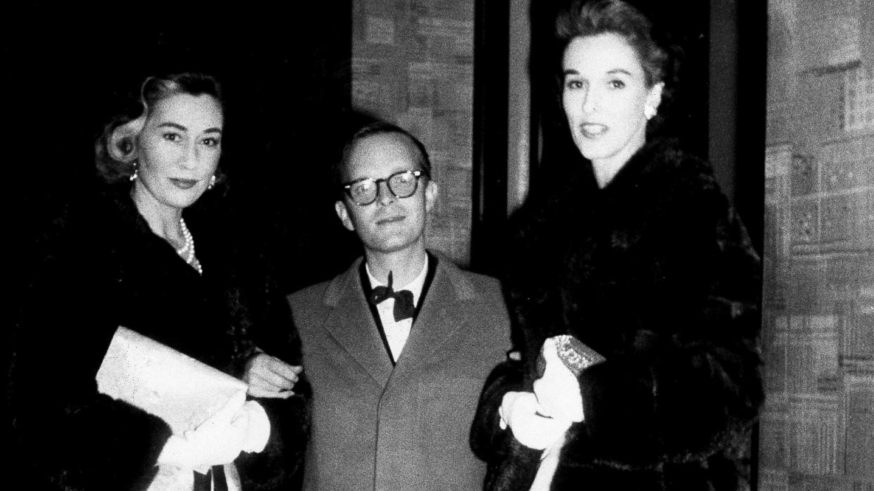 gloria guinness, truman capote, barbara paley stand together and wear coats and formal attire