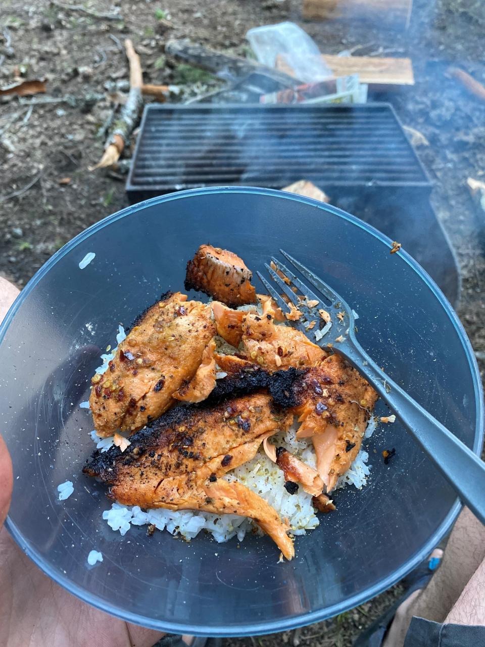 Cooking the salmon in a firepit blackens and crisps the skin, adding flavor and texture.