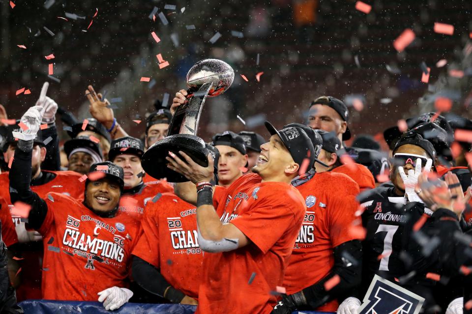 Cincinnati Bearcats quarterback Desmond Ridder (9) raises the championship trophy following the American Athletic Conference championship football game against the Tulsa Golden Hurricane, Saturday, Dec. 19, 2020, at Nippert Stadium in Cincinnati. The Cincinnati Bearcats won, 27-24. 