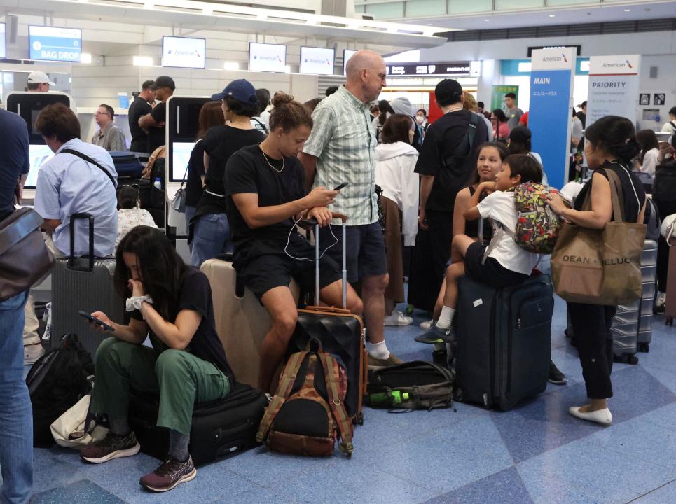 Passengers form a long line to check in at Haneda Airport in Tokyo on July 19, 2024. A massive technology outage has disrupted airports, and airlines, worldwide. ( The Yomiuri Shimbun via AP Images )