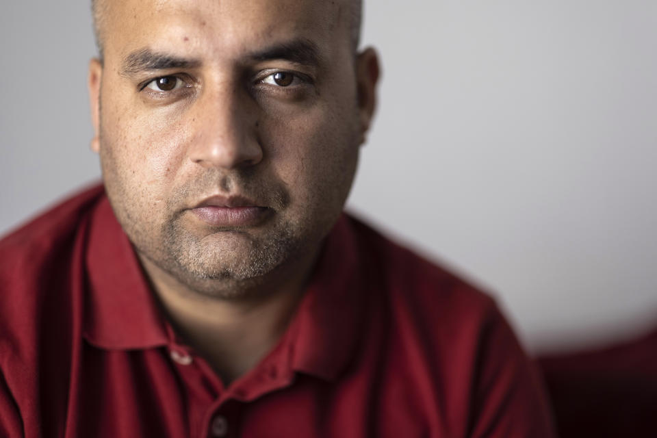 Afghanistan's Abdul Wali poses in his apartment in Strasbourg, eastern France, Sunday, Sept. 4, 2021. Wali took the last bus out of a huge makeshift migrant camp in the northern French port of Calais. His government bus took him to Strasbourg. “Now, I’m so happy to be here,” he said. “You’re not scared at night” like in the migrant camp nicknamed The Jungle. “You have your job. You have your work, you come back home. You pay your rent. You are a normal person.” (AP Photo/Jean-Francois Badias)