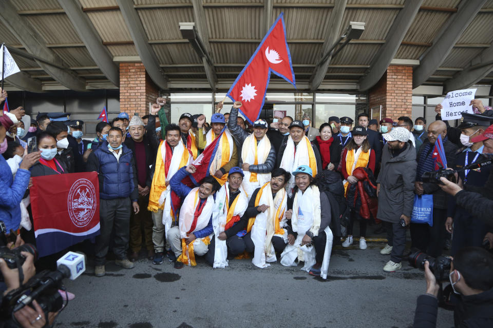 The all-Nepalese mountaineering team that became the first to scale Mount K2 in winter pose for the media as they arrive at Tribhuwan International airport in Kathmandu, Nepal, Tuesday, Jan. 26, 2021. (AP Photo/Niranjan Shrestha)