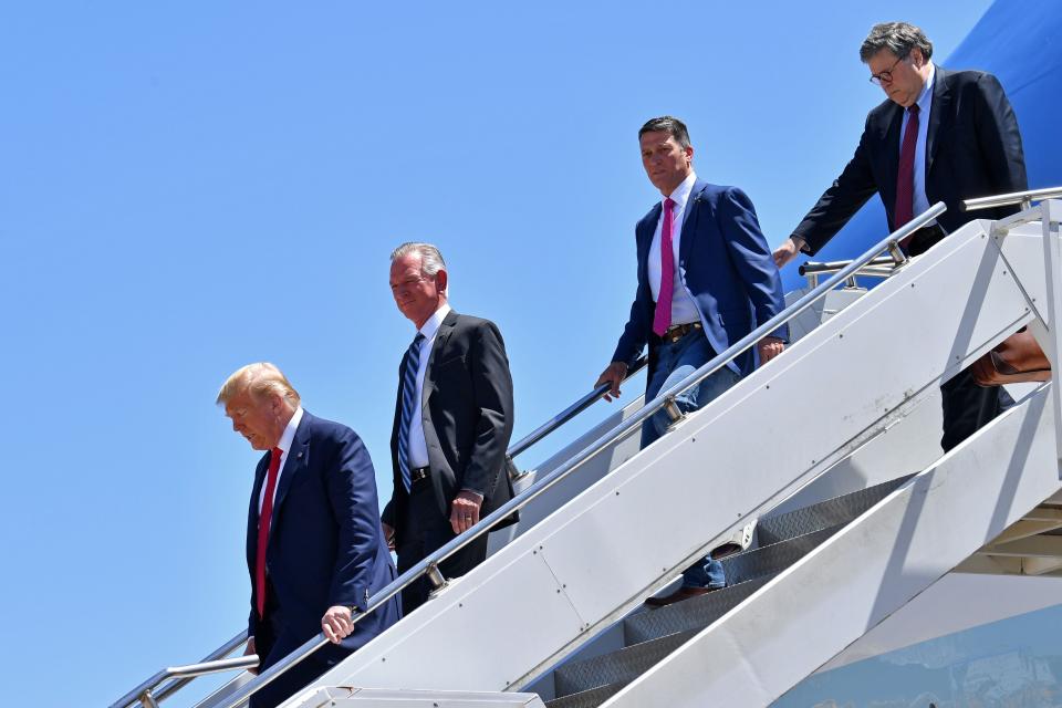 President Donald Trump steps off Air Force One, alongside Attorney General William Barr, U.S. House candidate Ronny Jackson (2nd from right), and U.S. Senate candidate Tommy Tuberville (2nd from left), upon arrival in Dallas, Texas, on June 11, 2020.