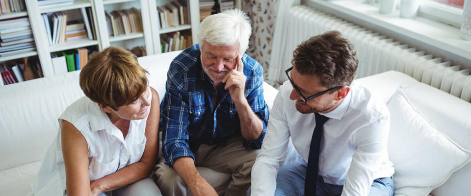 Senior couple speaking with advisor in living room