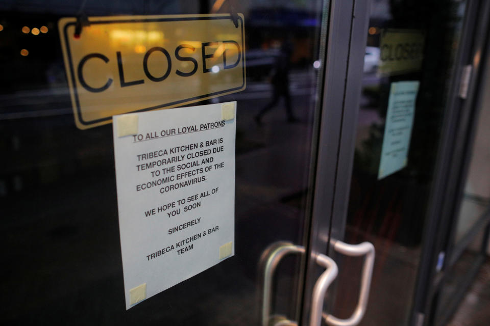 A sign announcing that Tribeca Kitchen and Bar is closed because of the coronavirus outbreak is displayed on a door in Seattle, Washington, U.S., March 13, 2020.   REUTERS/Brian Snyder