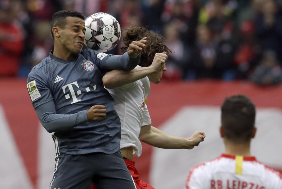 Bayern midfielder Thiago Alcantara, left, jumps for a header with Leipzig's Marcel Sabitzer during the German Bundesliga soccer match between Leipzig and Bayern Munich at the Red Bull Arena stadium in Leipzig, Germany, Saturday, May 11, 2019. (AP Photo/Michael Probst)