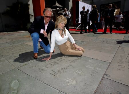 FILE PHOTO: Jane Fonda and her brother Peter Fonda look at their father's handprints and footprints after her hand and footprint ceremony in the forecourt of the Chinese theatre in Hollywood