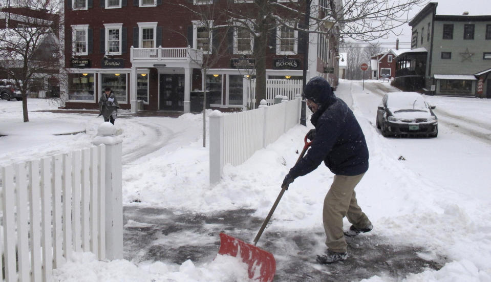 Bill Langley, of the Green Mountain Inn in Stowe, Vt., shovels snow from a sidewalk on Tuesday, Nov. 12, 2019. In the first significant snow of the season a wintry mix swept into northern New England, with hundreds of schools closed or delayed in Vermont due to snow, and slick conditions in New Hampshire and Maine. The National Weather Service says record cold could follow the snow. (AP Photo/Wilson Ring)