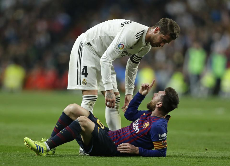 Barcelona forward Lionel Messi, bottom, argues with Real defender Sergio Ramos after a challenge during the Spanish La Liga soccer match between Real Madrid and FC Barcelona at the Bernabeu stadium in Madrid, Saturday, March 2, 2019. (AP Photo/Manu Fernandez)