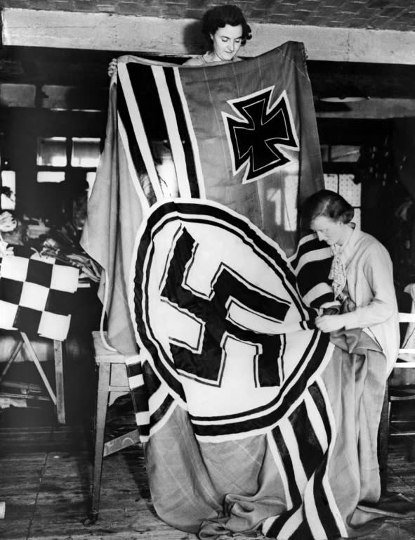 A picture dated 1936 shows German female workers making Third Reich flags with Nazi symbols including the Iron Cross and the Swastika designed by Hitler himself