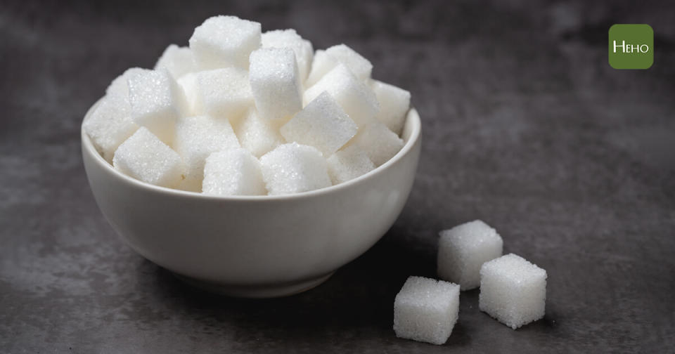 White sugar cubes in bowl on table.