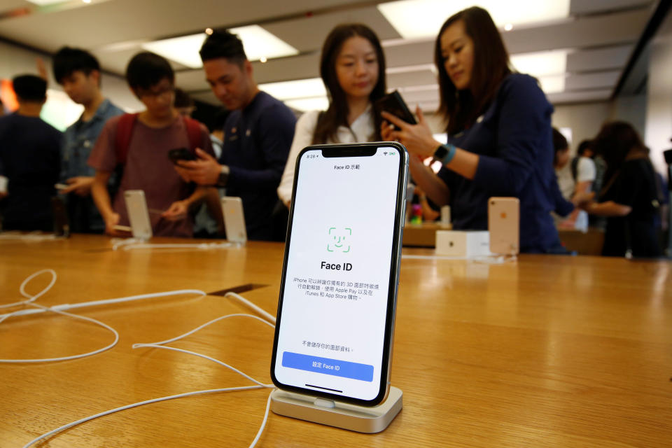 Customers buy iPhone X at an Apple Store in Hong Kong