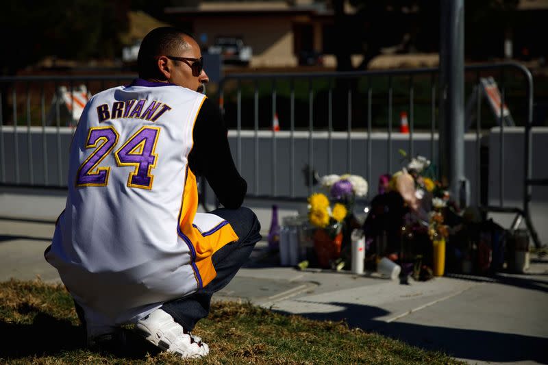 Adahir Farias, of Oxnard, pays his respects to victims at a makeshift memorial across from the helicopter crash site of NBA star Kobe Bryant in Calabasas