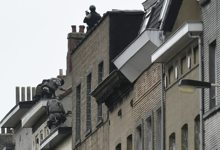 Security forces prepare to enter a building during an operation in the Molenbeek district of Brussels on November 16, 2015