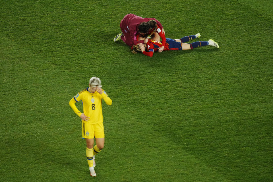 Sweden's Lina Hurtig, left, reacts as Spain players celebrate after their win in the Women's World Cup semifinal soccer match between Sweden and Spain at Eden Park in Auckland, New Zealand, Tuesday, Aug. 15, 2023. (AP Photo/Abbie Parr)