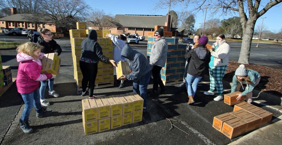 Cases are sorted and restacked after several pallets of Girl Scout cookies were unloaded early Saturday morning, Jan. 13, 2024, in the parking lot of Aldersgate UMC in Shelby.