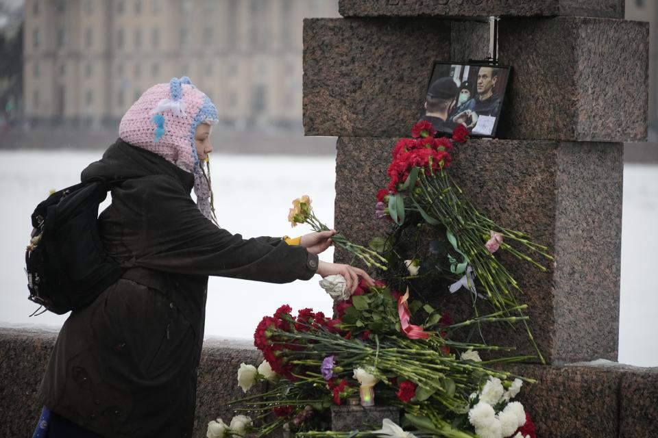A girl lays flowers paying the last respect to Alexei Navalny at the Memorial to Victims of Political Repression in St. Petersburg, Russia on Saturday, Feb. 17, 2024. Russian authorities say that Alexei Navalny, the fiercest foe of Russian President Vladimir Putin who crusaded against official corruption and staged massive anti-Kremlin protests, died in prison. He was 47. (AP Photo/Dmitri Lovetsky)
