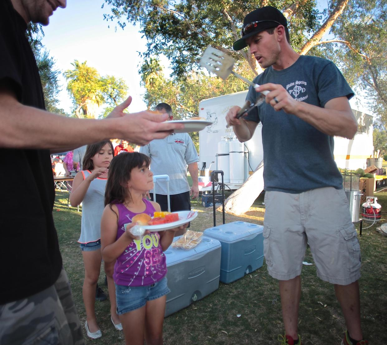 Firefighter Matt Kearney grills hamburgers for guests of the annual fish fry hosted by the Palm Springs Firemen’s Association in Palm Springs. This year's event will take place on June 4.