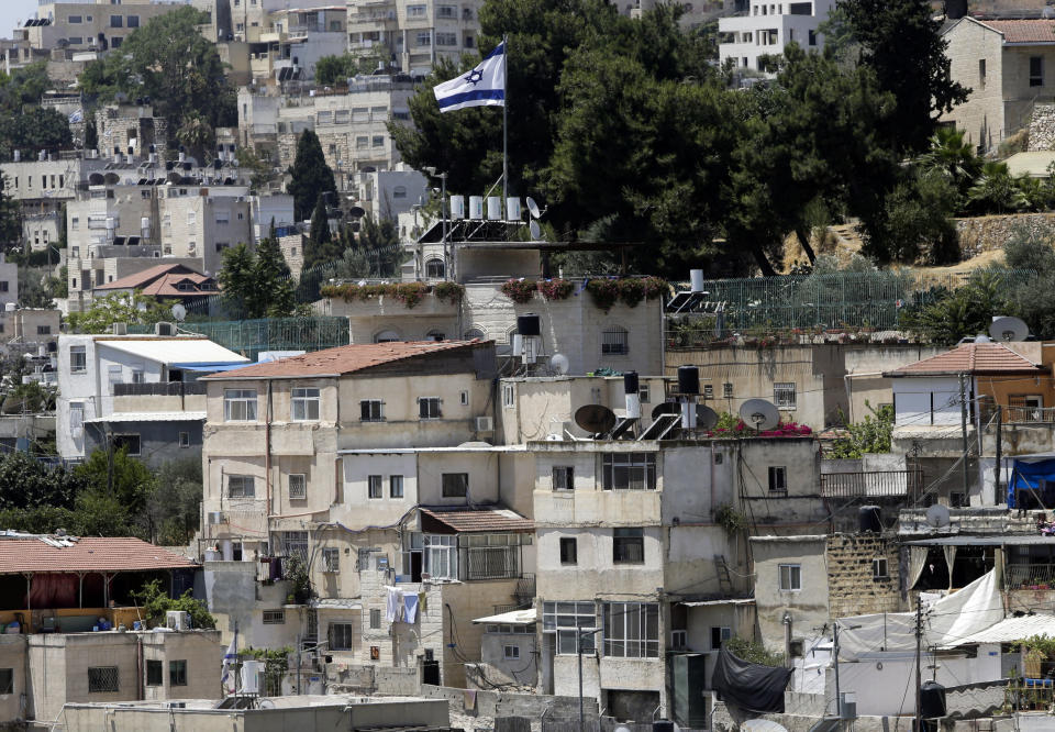 An Israeli flag flies over a Jewish owned house in a Palestinian neighborhood of Silwan in east Jerusalem, Wednesday, July 1, 2020. Israeli leaders paint Jerusalem as a model of coexistence, the "unified, eternal" capital of the Jewish people, where minorities have equal rights. But Palestinian residents face widespread discrimination, most lack citizenship and many live in fear of being forced out. (AP Photo/Mahmoud Illean)