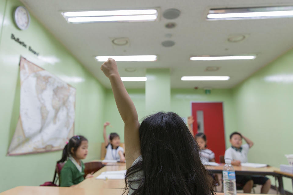 A pupil raises her hand during class at the Jongno Hagwon Academy in Seoul on Aug. 10, 2016.<span class="copyright">Yelim Lee—AFP/Getty Images</span>