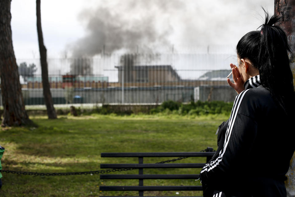 Smoke billows from Rebibbia prison following inmates' protests, in Rome, Monday, March 9, 2020. Italian penitentiary police say six inmates protesting coronavirus containment measures at the northern Italian prison of Modena have died after they broke into the infirmary and overdosed on methadone. The protest Sunday in Modena was among the first of more than two-dozen riots at Italy's overcrowded lock-ups that grew Monday. (Cecilia Fabiano/LaPresse via AP)