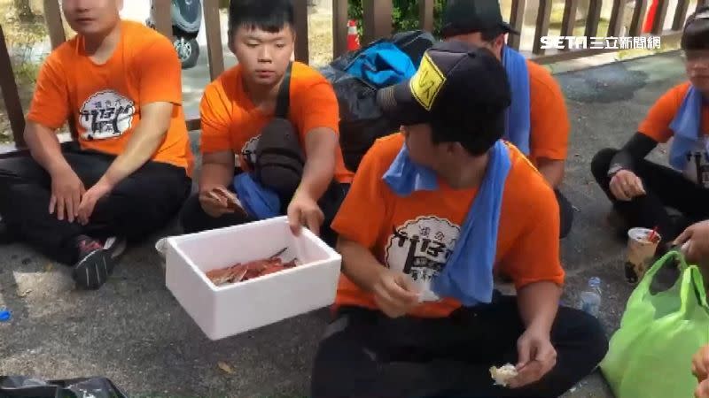 轎班人員蹲坐在大馬路上大嗑螃蟹。